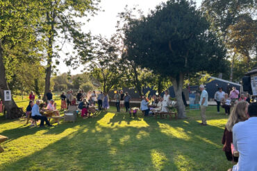 People sitting in the garden on a summer day as the presentations take place