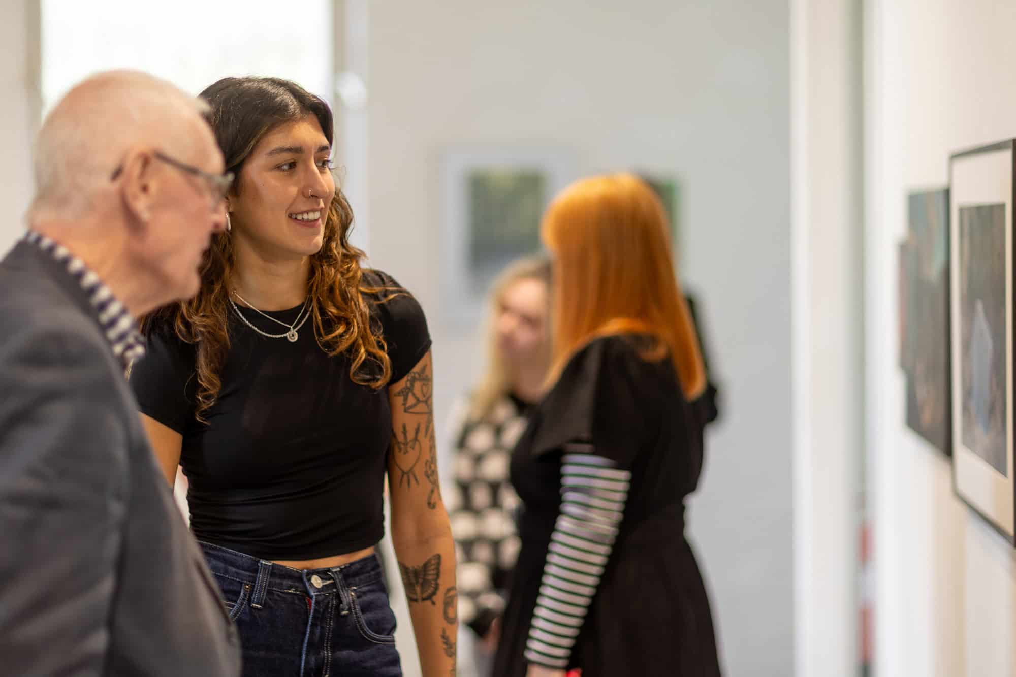 People looking at artwork on the walls of the exhibition gallery