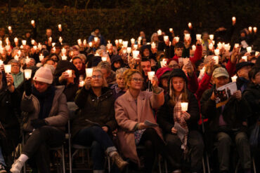 Mountbatten Isle of Wight's Light up a Life event in 2024 showing people sat on chairs outside holding candle lights