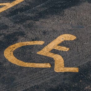 Disabled parking bay painted in yellow on tarmac