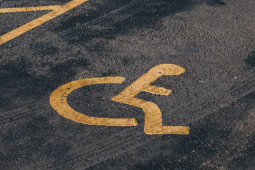 Disabled parking bay painted in yellow on tarmac