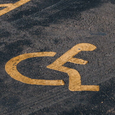Disabled parking bay painted in yellow on tarmac