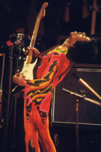Jimi Hendrix playing guitar on stage