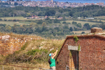 Person photographing part of Bembridge Fort, with the Solent and Mainland in the distance