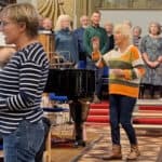 Pam Wedgwood, centre, and Lesley Mariner, conducting the Dementia Friendly choir and the Bay Wailers