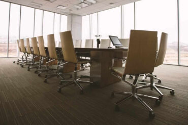board room table and chairs in sky scraper with floor to ceiling glass windows