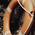 orange life ring leaning up against a wall