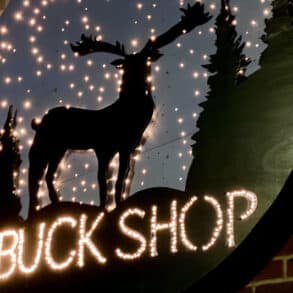 Close up of the Buckshop sign, showing the silhouette of a reindeer with lights around it
