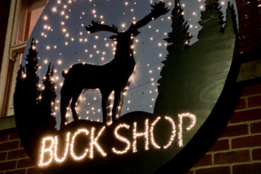 Close up of the Buckshop sign, showing the silhouette of a reindeer with lights around it