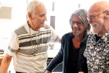 Three men laughing together at the Men's art club