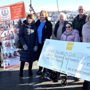 Sam O’Rourke, from the IW Foundation, presents the cheque to volunteers and committee members from Cowes Sailability