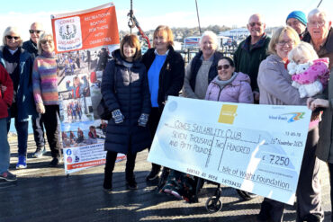 Sam O’Rourke, from the IW Foundation, presents the cheque to volunteers and committee members from Cowes Sailability