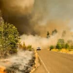 car driving through lots of smoke from wildfire