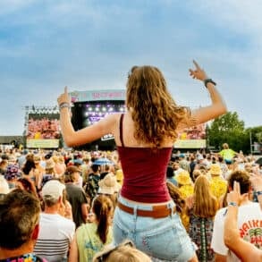 Large crowds of people watching the main stage performance at Isle of Wight Festival