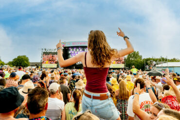 Large crowds of people watching the main stage performance at Isle of Wight Festival