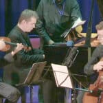 Musicians on stage playing string instruments