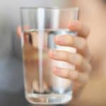 Person holding a glass of water