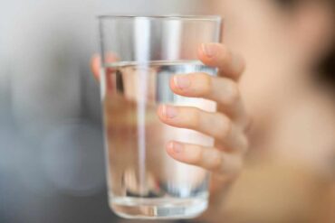 Person holding a glass of water