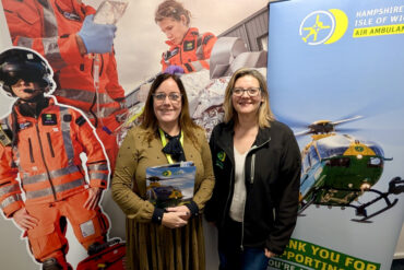 Two women standing in from of an Air Ambulance banner