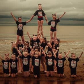 Starlight Cheerleading team posing for photo on the beach