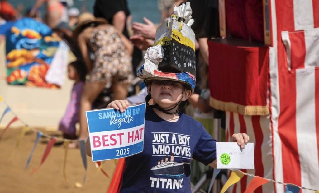 Child with handmade hat with winning certificate