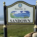 Welcome to Sandown sign with bay in the background