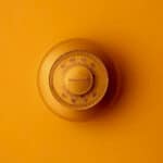 a room thermostat on an orange wall