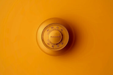 a room thermostat on an orange wall