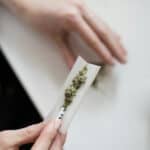 a woman rolling a cannabis joint