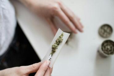 a woman rolling a cannabis joint