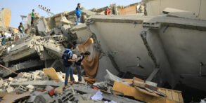 bombed homes in Gaza with young men climbing over the rubble searching for victims