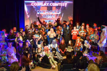 Lots of people on stage dressed in cosplay for the cosplay competition