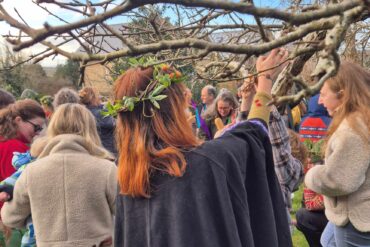 Moonshine Border Morris dancers wassailing around a tree