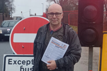 andrew garratt standing by the road closed sign on horsebridge hill