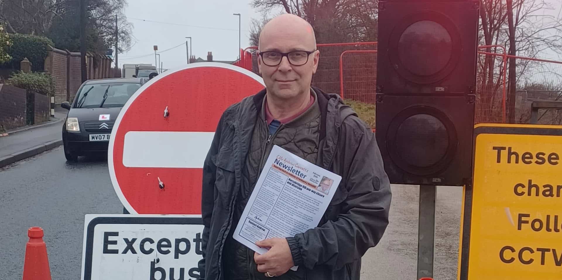 andrew garratt standing by the road closed sign on horsebridge hill