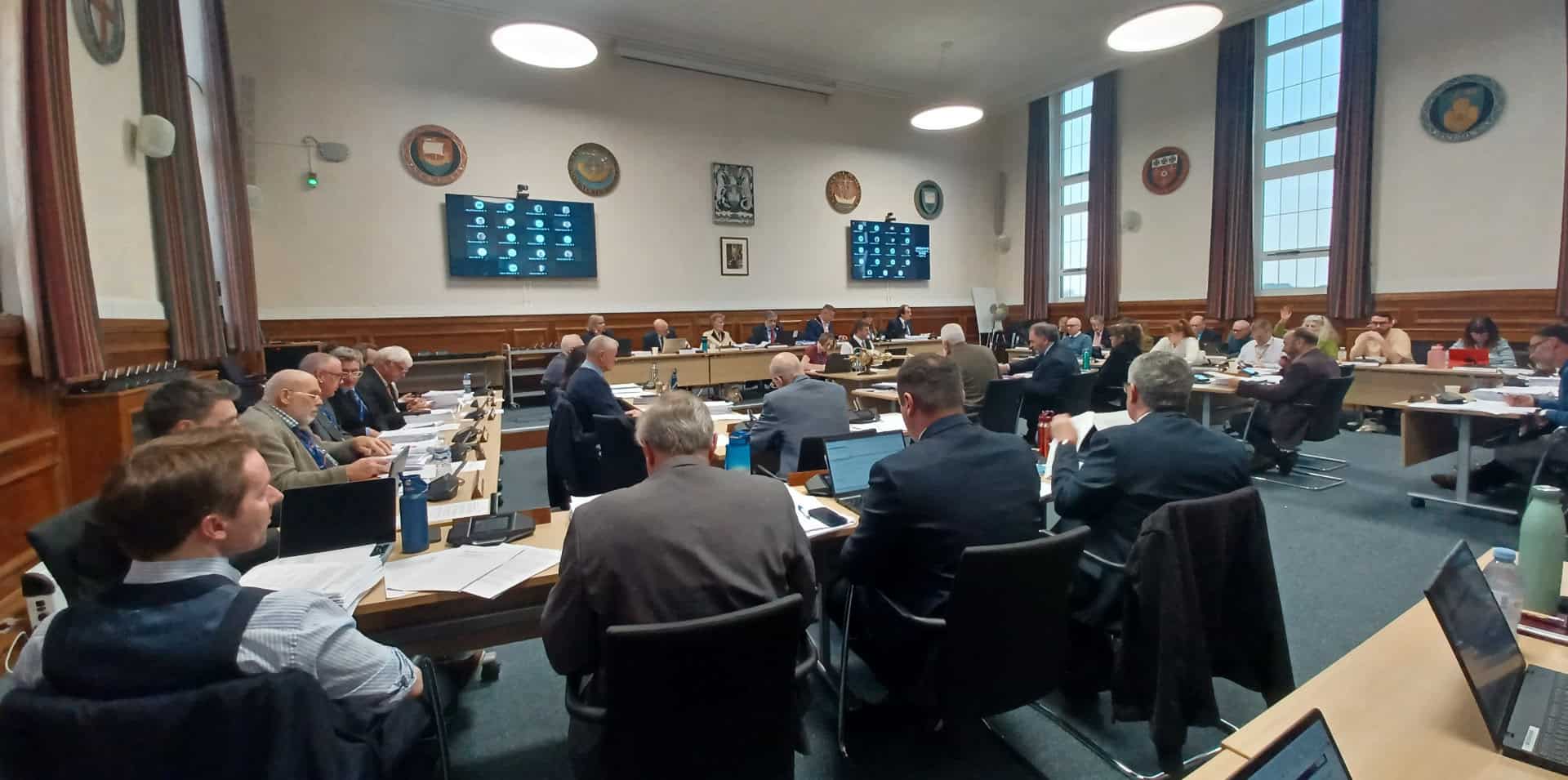 county hall budget meeting showing councillors sitting at desks