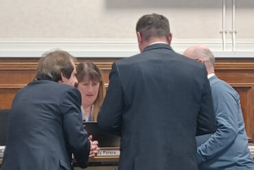 leaders conferring in council meeting