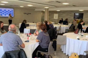 People sitting at round tables during the mountbatten conference 2025