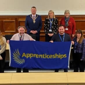 Councillors and staff holding up the national apprenticeship week flag