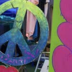 Large CND peace symbol and love hearts painted on plywood at Three Rivers Festival