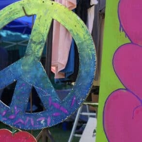 Large CND peace symbol and love hearts painted on plywood at Three Rivers Festival