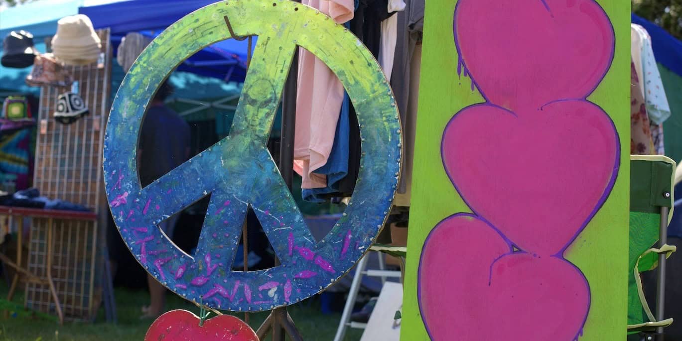 Large CND peace symbol and love hearts painted on plywood at Three Rivers Festival