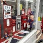 postman looking through the window at the postbox display
