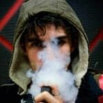 teenage male with hoodie vaping