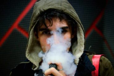 teenage male with hoodie vaping