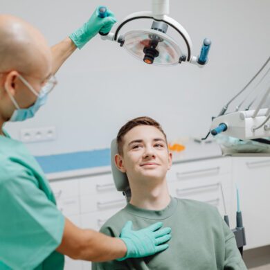 Dental patient sitting in dentist's chair with dentist standing over him