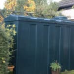 A Domestic Heating Oil tank in a garden next to a cottage