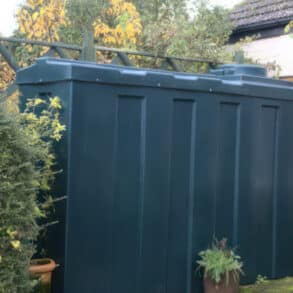A Domestic Heating Oil tank in a garden next to a cottage
