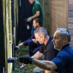 People painting a fence
