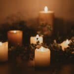 Several candles intertwined with foliage